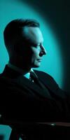 A man in a suit and tie sitting in a chair photo