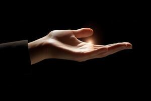 A human hand reaching out with a glowing orb, set against a dark background, symbolizing hope photo