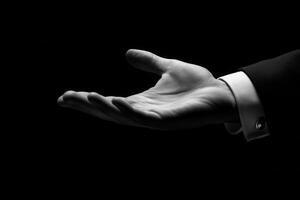 Elegant hand gesture in a dark setting, symbolizing invitation or offering assistance photo