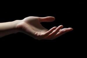A close-up of an open human hand reaching out against a dark background, symbolizing connection photo