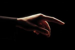 Elegant hand gesture reaching out against a dark background, conveying connection and intention photo
