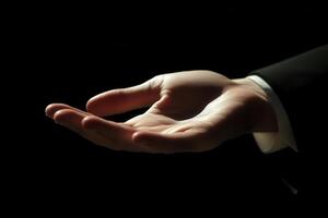 Elegant hand gesture in a dark setting, suggesting invitation or offering, with soft lighting photo