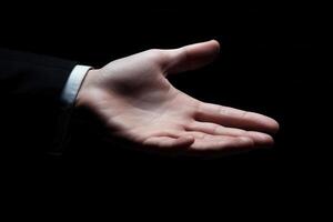 Elegant hand extended in greeting against a dark backdrop, suggesting connection and welcome photo