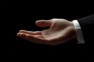 Elegant open hand gesture in a dark setting, symbolizing invitation or offering photo