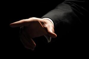 Elegant hand gesture in a dark setting, suggesting invitation or direction with style photo