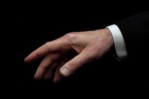 Elegant human hand reaching out against a dark background, showcasing fine details photo