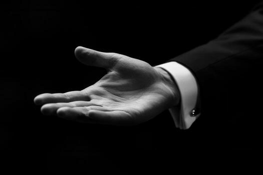 Elegant outstretched hand in a formal suit against a dark background, inviting gesture photo