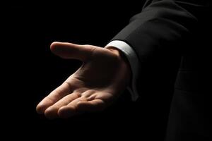 Elegant hand gesture in a formal suit against a dark background, conveying invitation or greeting photo