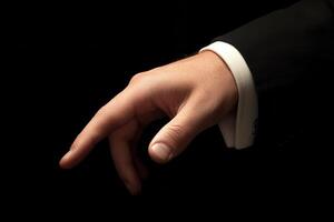 Elegant hand gesture in a formal suit, symbolizing sophistication and invitation photo