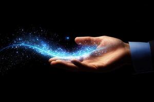 A human hand gracefully displaying a shimmering blue light against a dark background photo