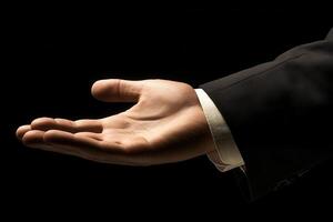 Elegant hand gesture of a businessman extending his palm against a dark background photo