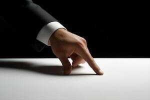 Elegant hand in suit poised above a white surface, creating a dramatic contrast in a dark setting photo