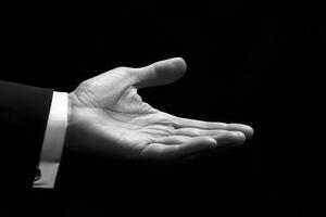 Elegant open hand gesture in black and white, symbolizing invitation or offering photo