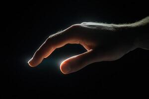 A human hand reaching out with soft lighting, symbolizing connection and hope in darkness photo