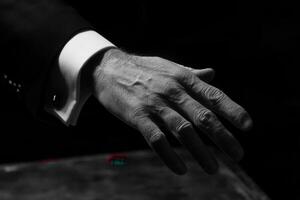 Elegant hand reaching towards a vintage table, showcasing intricate details and textures photo