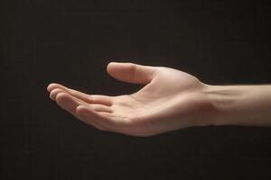 A graceful human hand reaching out against a dark background, symbolizing connection and openness photo