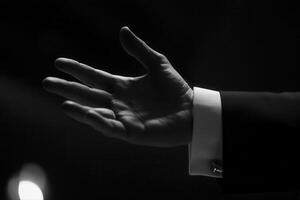 Elegant hand gesture in a dimly lit setting, suggesting a moment of communication or invitation photo