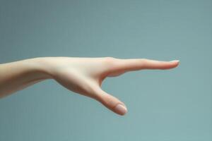 Elegant human hand reaching out against a soft blue background, showcasing grace and poise photo