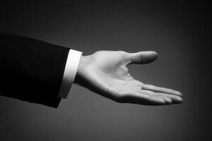 Elegant hand gesture in a formal suit, symbolizing invitation or agreement against a dark backdrop photo