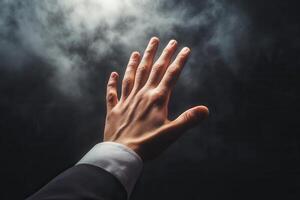 A hand reaching out through misty darkness, symbolizing hope and aspiration photo