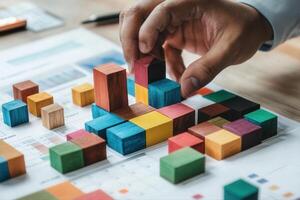 Colorful wooden blocks being arranged on a desk, with charts and documents in the background photo