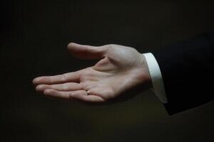Elegant hand gesture in a formal setting, showcasing a ring, with a blurred background photo