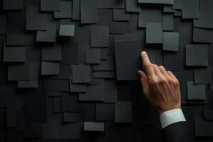 A business professional interacting with a textured black wall of blank cards, symbolizing creativity photo