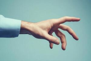 A human hand reaching out with a gentle gesture against a soft blue background photo