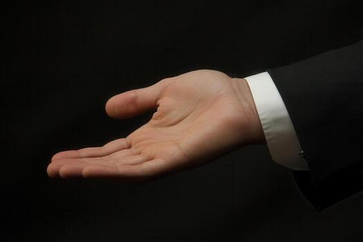 Elegant open hand gesture of a businessman against a dark background, symbolizing invitation photo