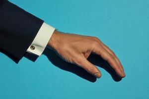 Elegant business hand gesture on a vibrant blue background, suggesting professionalism photo
