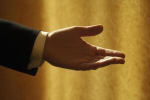 Elegant hand reaching out against a softly lit background, suggesting invitation or greeting photo