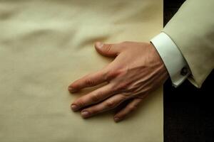 Elegant hand resting on textured paper, showcasing subtle details in a warm, artistic setting photo