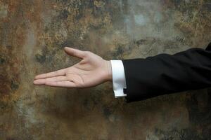 Elegant hand gesture in formal attire against a textured background, suggesting invitation photo