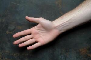 A close-up of an outstretched human hand against a textured dark background photo