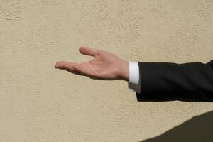 Elegant hand gesture against a textured wall, suggesting invitation or greeting photo