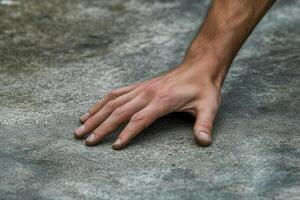 Close-up of a human hand resting on a textured surface, highlighting skin tones and details photo