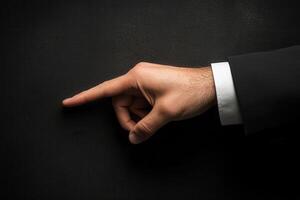 Elegant hand gesture pointing towards a dark surface, suggesting emphasis or direction photo