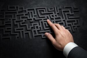A business professional navigating a complex maze design with a focused hand gesture photo