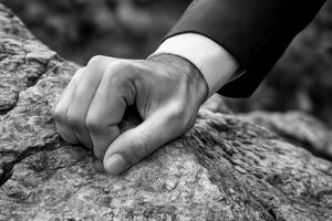 A determined hand gripping a rocky surface, symbolizing perseverance in nature photo
