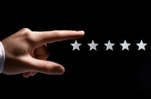 Hand reaching toward five empty stars on a black background, symbolizing rating or review photo