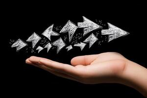Hand holding a series of sparkling arrows pointing forward against a black background photo
