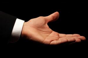 Outstretched hand in a formal setting, inviting collaboration, against a dark background photo
