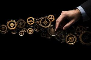 Hand adjusting vintage clock gears against a black background, symbolizing time and precision photo