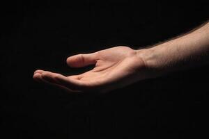 Outstretched hand against a dark background, symbolizing openness and invitation photo