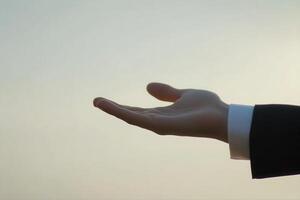 Outstretched hand reaching towards the horizon during sunset, symbolizing hope and opportunity photo