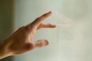 Hand reaching towards a reflective surface, capturing a moment of contemplation indoors photo