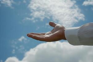 Open hand reaching towards a bright sky with fluffy clouds, symbolizing hope and opportunity photo