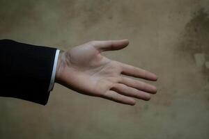 Open hand gesture against a textured background, symbolizing greeting or offering help photo