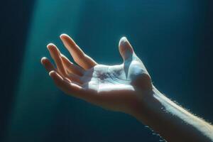Hand reaching out towards a soft light, symbolizing hope and connection in a serene setting photo