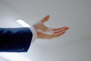Outstretched hand in business attire signaling for attention in a modern office setting photo